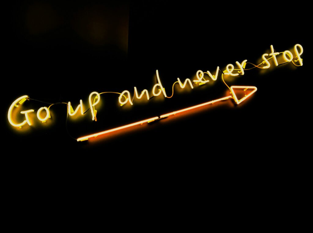 a neon sign with a arrow pointing to it