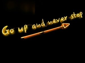 a neon sign with a arrow pointing to it